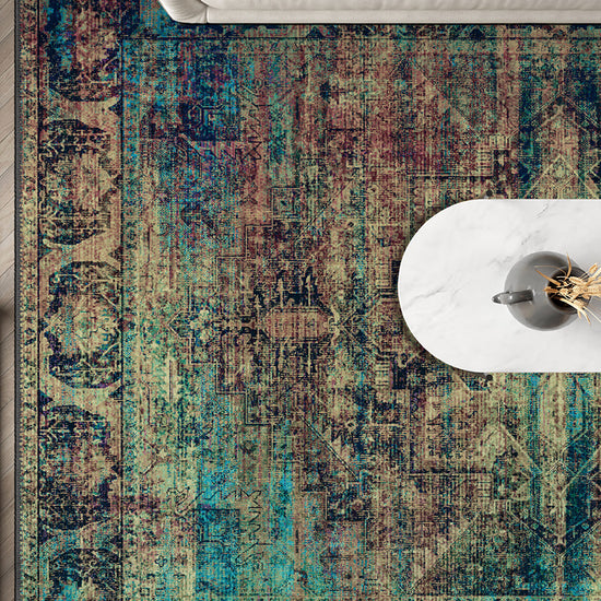 Multicolored patterned rug on a wooden floor with a white chair and table.