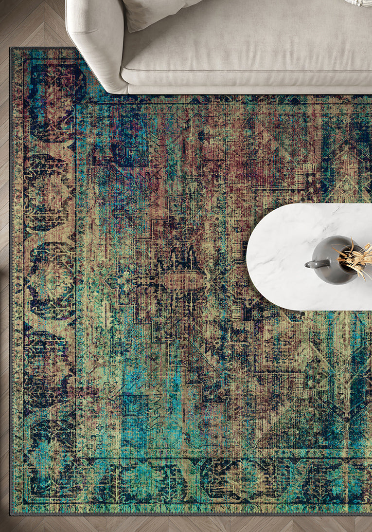 Multicolored patterned rug on a wooden floor with a white chair and table.