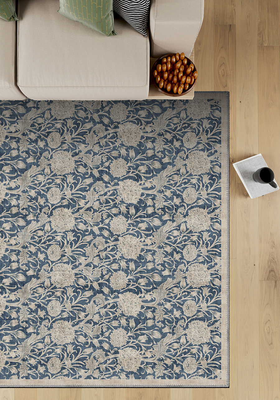Floral patterned rug on a wooden floor with a sofa and decorative items.